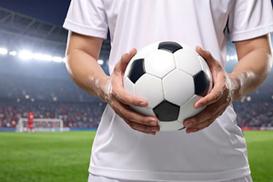 Soccer player holding ball in stadium lights, a Sports & Recreation Photo by Davizro's Market
