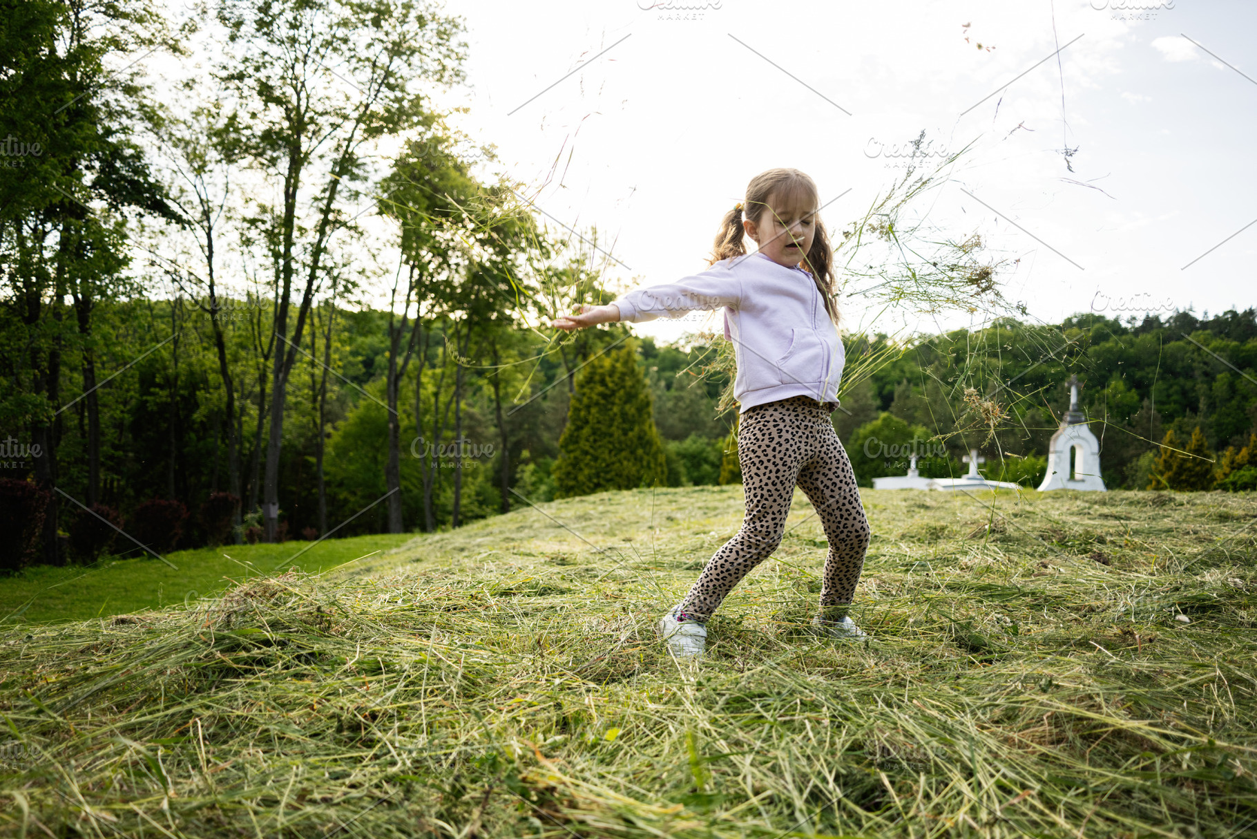 Young girl enjoying nature while playing outdoors in a grassy field, a Person Photo by AS photostudio