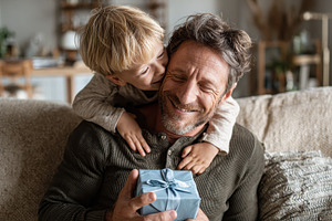 Father receiving gift from son happy, a Photo by Pixeness Studio