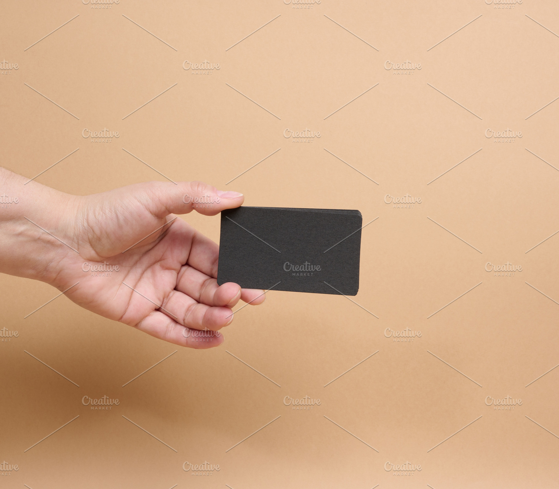 A person holding a stack of black business cards against a beige, a Business Photo by ndanko