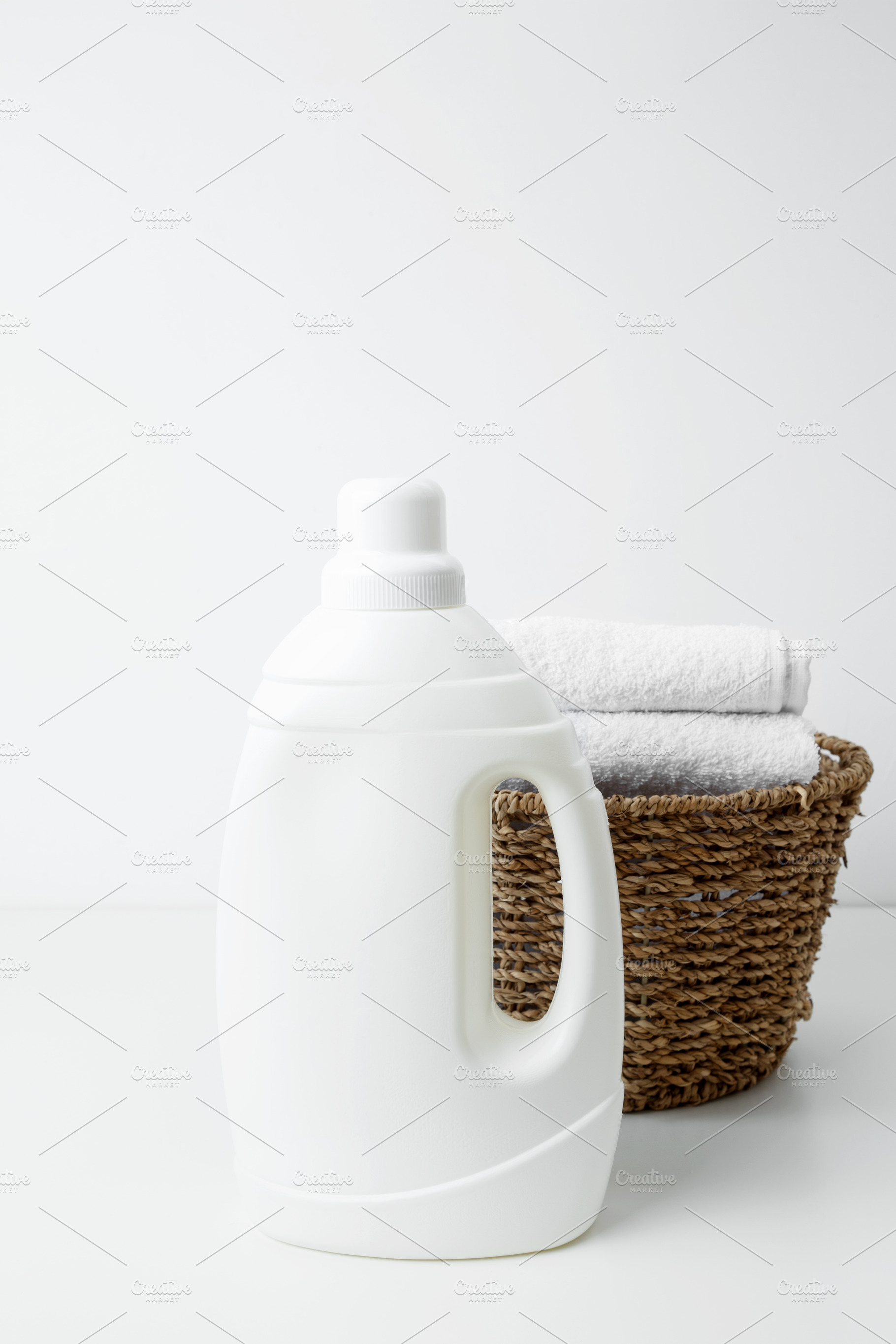 Laundry detergent branding mock up and basket filled with clean white towels. H, a Photo by matucha