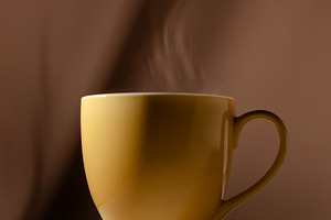 Hot coffee cup with steam rising in warm light. Morning routine, a Photo by salmon.black