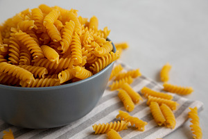Dry Fusilli Pasta in a Bowl, low angle view. Copy space., a Food & Drink Photo by LiudmylaChuhunova