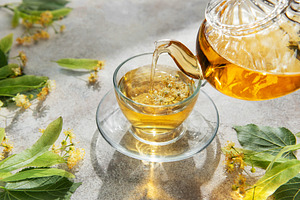 Pouring linden tea into glass cup for relaxation, a Food & Drink Photo by Olena Rudo