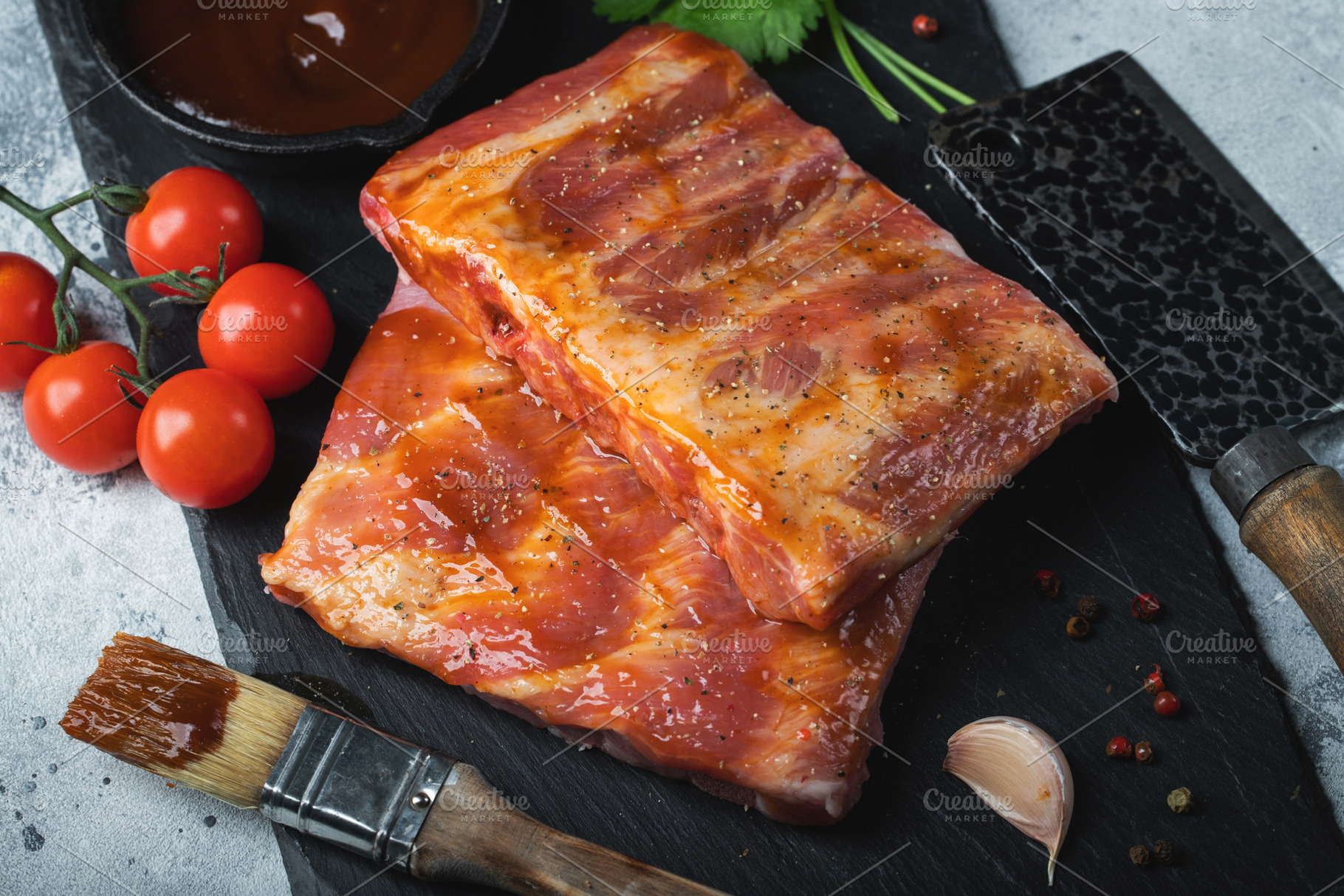 Ready for BBQ raw pork spare ribs with barbecue sauce. Black background. Top vi, a Food & Drink Photo by Budarinphoto