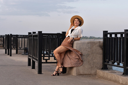 Cheerful woman posing by railing