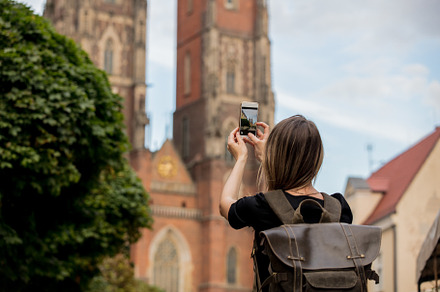 young girl with a smartphone on the background of the old church, a Person Photo by Masson Simon