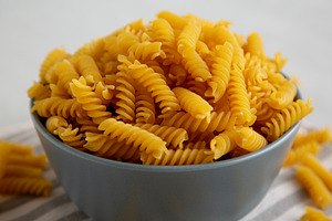 Dry Fusilli Pasta in a Bowl, low angle view. Close-up., a Food & Drink Photo by LiudmylaChuhunova