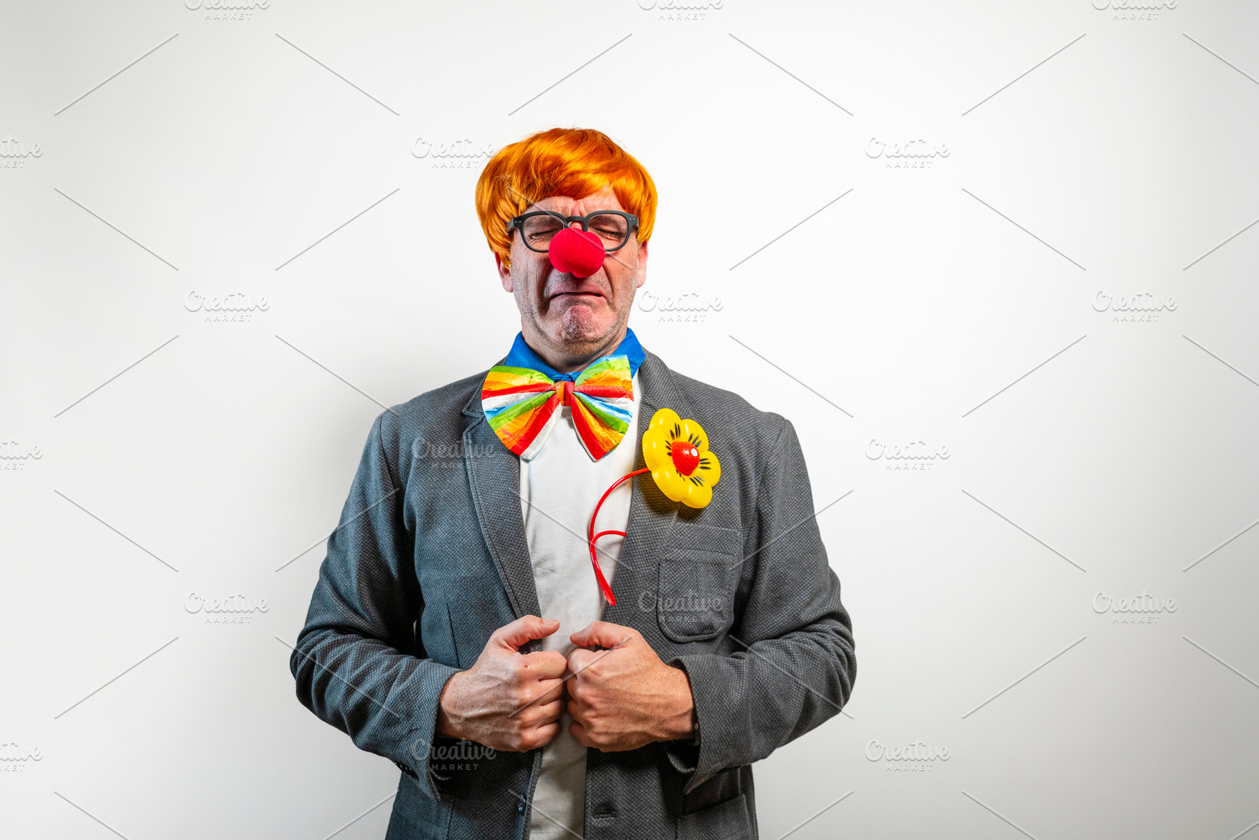 Clown experiencing sadness and crying wearing a business suit, a Person Photo by karrastock