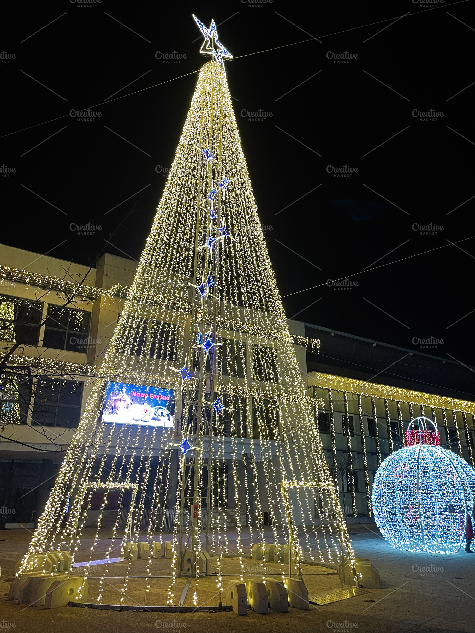 Illuminated Christmas tree and decorations at night in festive city center in M, a Photo by AS photostudio