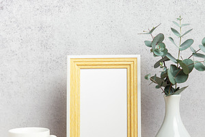 Empty photo frame, coffee cup and eucalyptus branches on table, a Business Photo by Olena Rudo