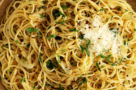 Homemade Italian Spaghetti Aglio e Olio on a Plate, top view. Fl, a Food & Drink Photo by LiudmylaChuhunova