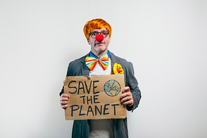 Clown holding save the planet sign on white background, a Person Photo by karrastock