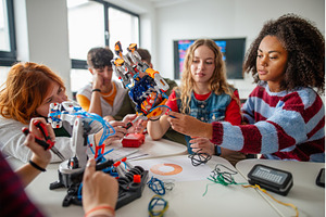 Team of teenagers assembling robotic, a Technology Photo by HalfPoint