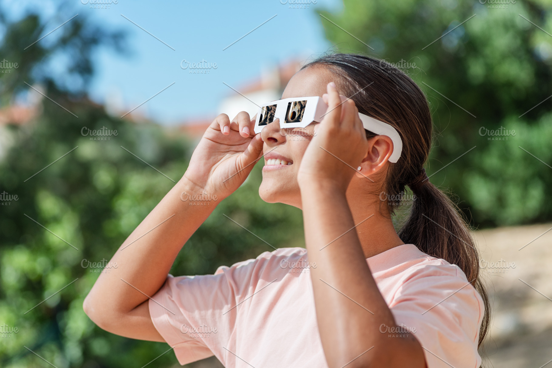 Young girl watches a solar eclipse, a School & Education Photo by Volff