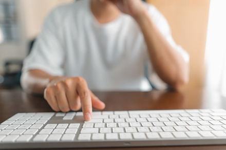 Man working at home, hands pressing computer keyboard, working a, a Business Photo by Art Rachen