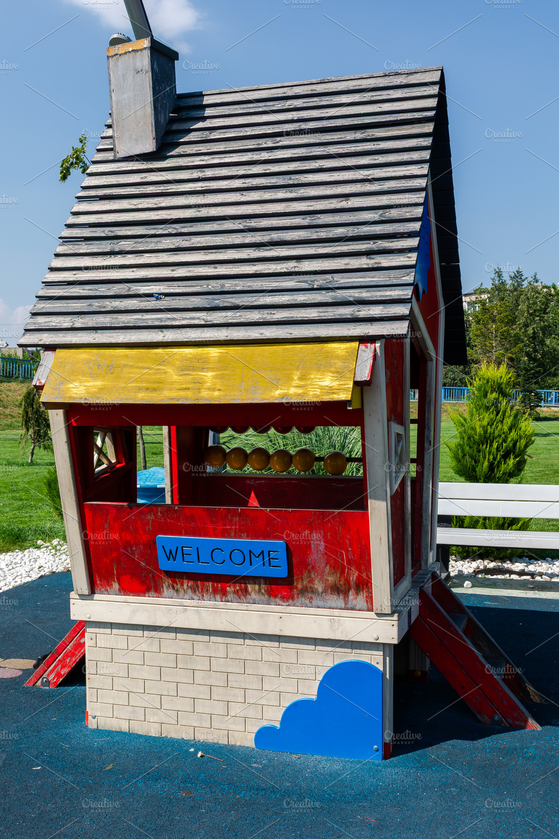 Vibrant children's playhouse with a welcome sign, wood roof, and red walls, set, a Person Photo by Ales Munt