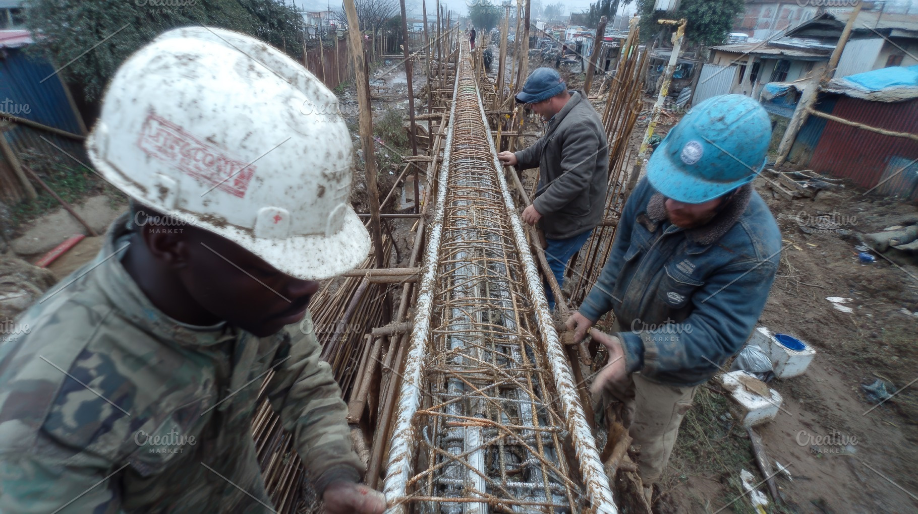 Construction workers assembling rebar reinforcement at a civil engineering site, an Industrial Photo by AS photostudio