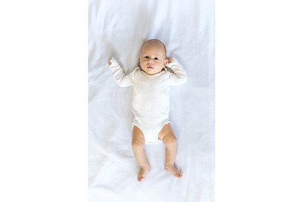 A newborn baby lies on a white bed, a Person Photo by yanadjana