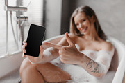 Lady holding smartphone and pointing at blank screen, showing ad, relaxing in f, a Photo by Prostock-Studio (Thumbnail 1 of 2)