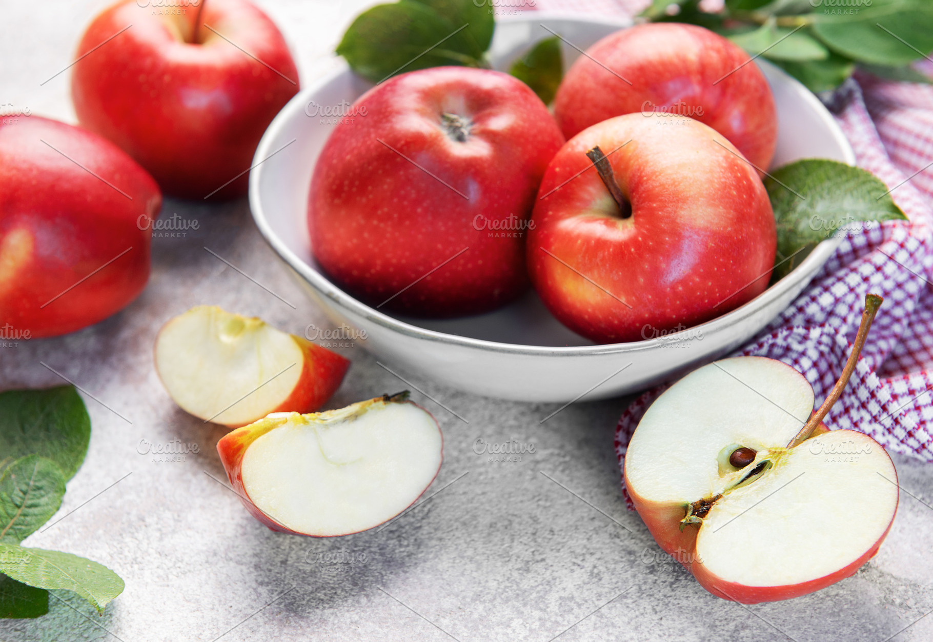 Red apples in bowl with slices on table, a Food & Drink Photo by Olena Rudo