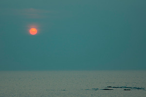 Minimalist moody sunset over calm sea with red sun and teal copy, a Photo by Pictures for you!!!!!!!!!
