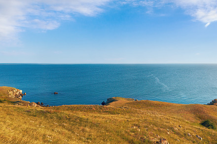 Sea beach with small rocky lagoon and coastal grass., a Nature Photo by YuriyB