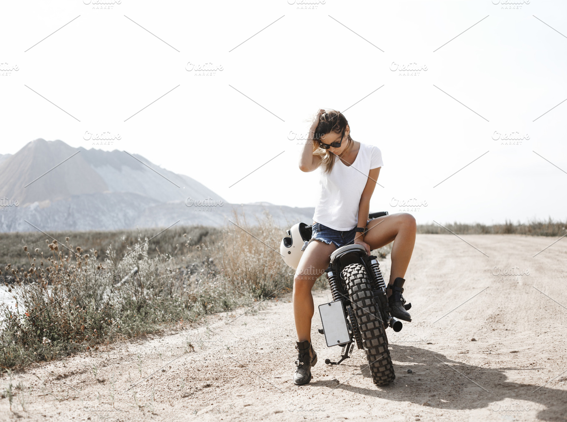Woman and motorcycle on road stock photo containing background and retro, a Transportation Photo by Aliaksei Kaponia