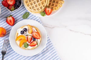 Stack of belgian waffles yogurt, fresh fruits and berry for brea, a Food & Drink Photo by Rimma
