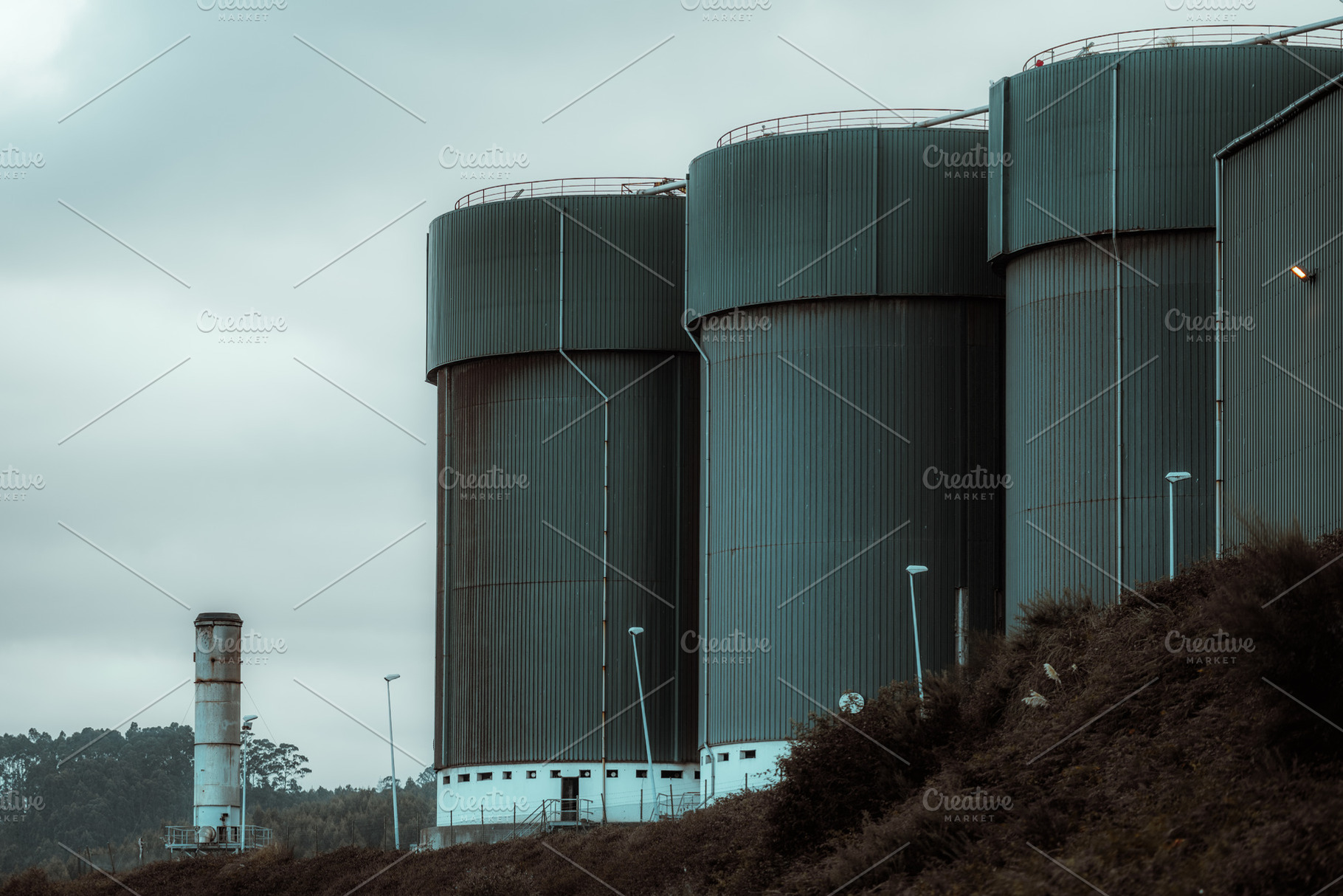 Industrial silos under cloudy sky, an Industrial Photo by SkyNext
