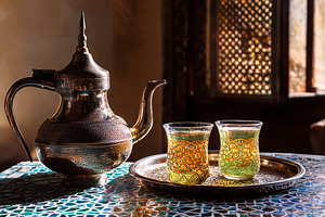 Moroccan tea on ceramic mosaic table in a room, a Food & Drink Photo by Davizro's Market