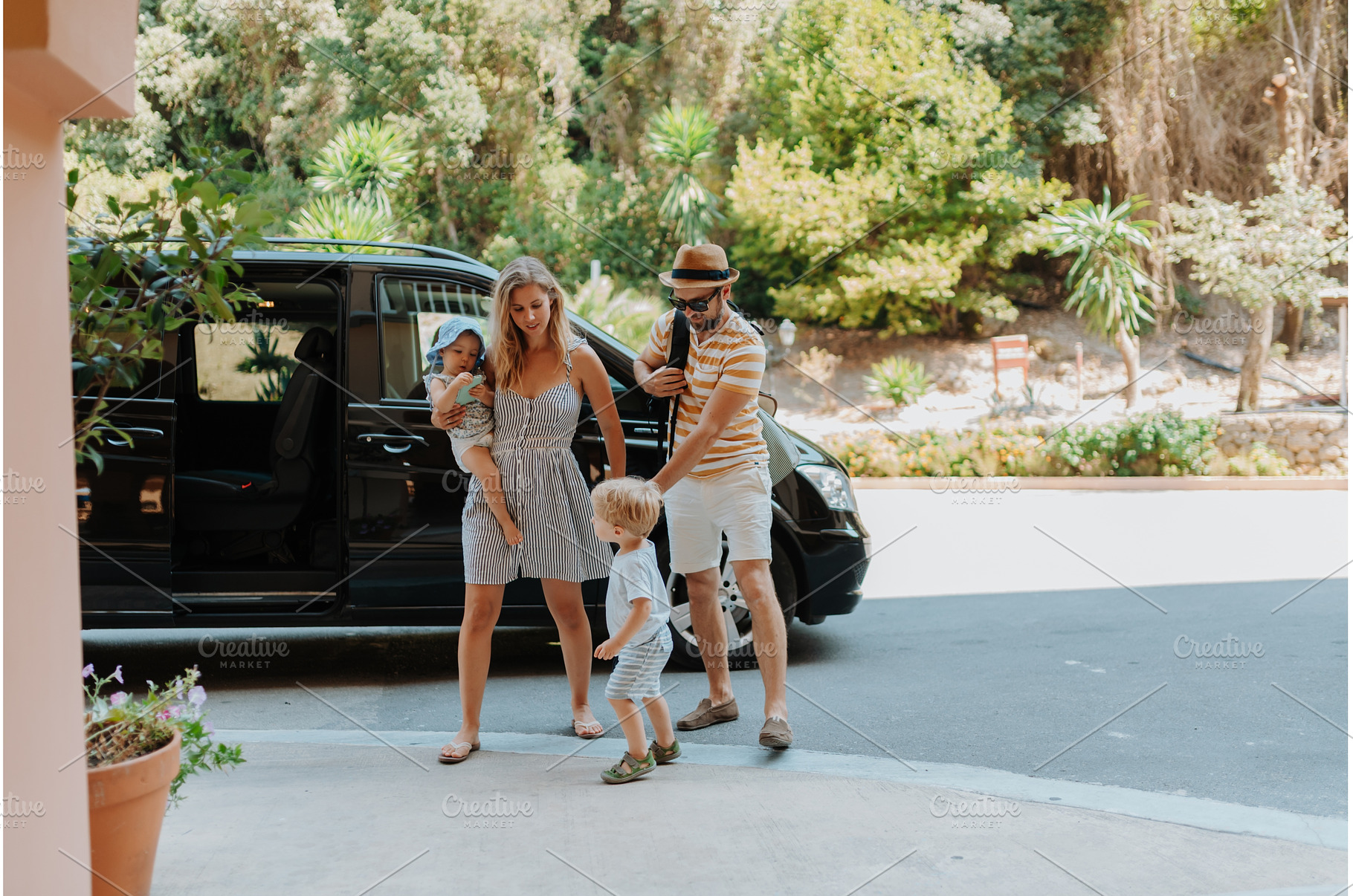 Parents with toddlers boarding car, a Transportation Photo by HalfPoint