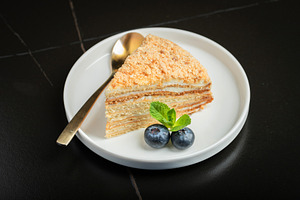 Medovik. Honey cake made from honey cakes with whipped sour cream, decorated wi, a Food & Drink Photo by Budarinphoto
