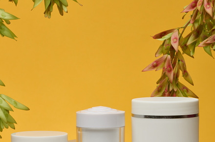 Three white cosmetic jars without labels stand on a white backgr