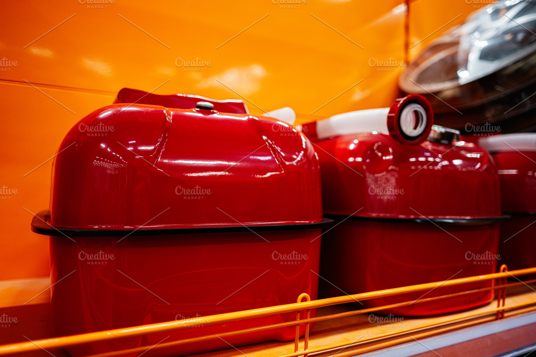 Bright red containers displayed on orange background in a retail store setting, a Photo by AS photostudio