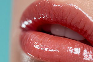 Close up of a woman's full lips applying shiny pink lip gloss, h, a Beauty & Fashion Photo by Studio ANNA