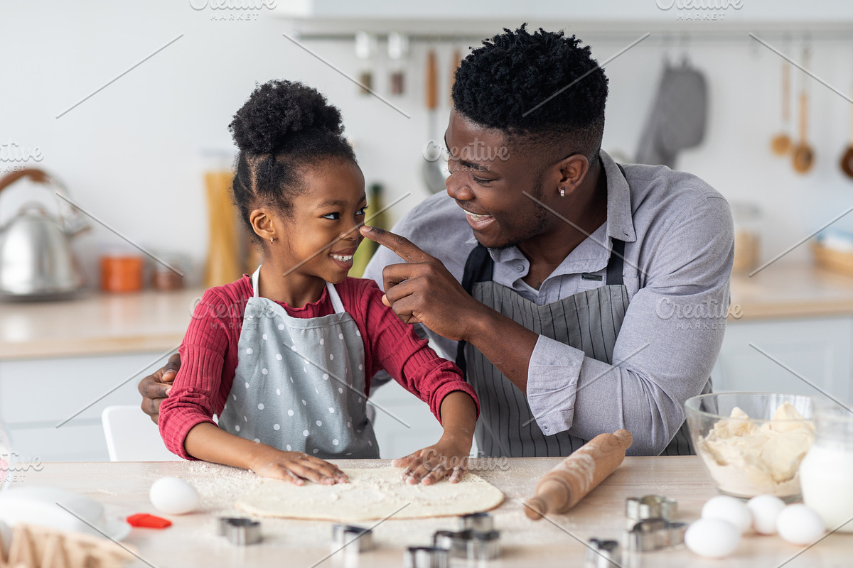 Loving african american family haivng fun while baking at home, a Photo by Prostock-Studio (Photo 1 of 2)