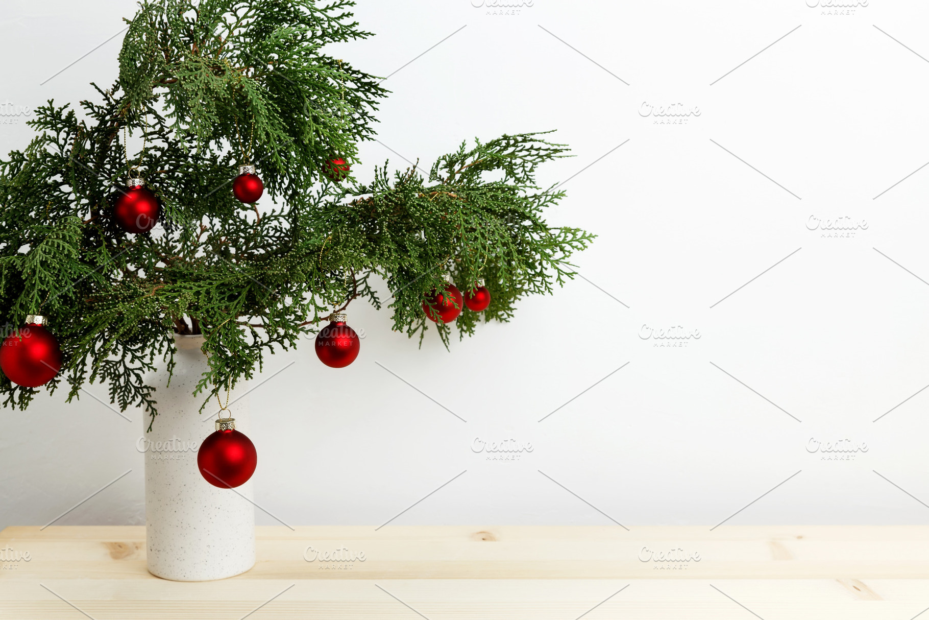 Vase with thuja branches and hanging Christmas ornaments creating a festive dis, a Photo by matucha