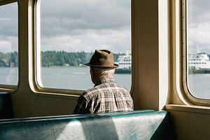 Elderly Man Looking Out Ferry Window, a Person Photo by Virgo Studio