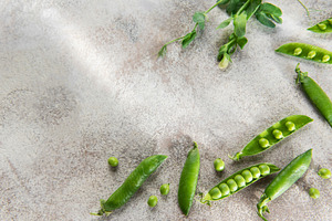 Fresh green pea pods and tendrils on table surface, a Food & Drink Photo by Olena Rudo