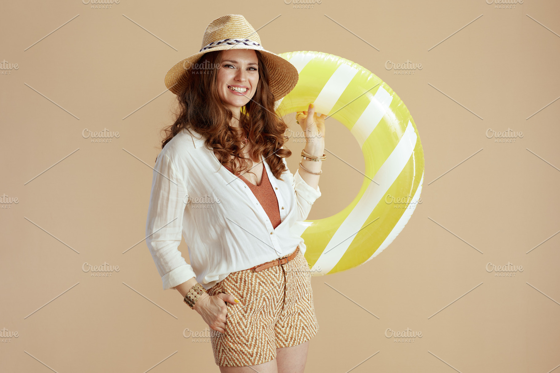 smiling trendy housewife in blouse and shorts on beige, a Person Photo by Alliance Images
