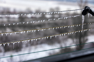 Close-up of icicles hanging from power lines in winter, with a b, an Architecture Photo by Ales Munt