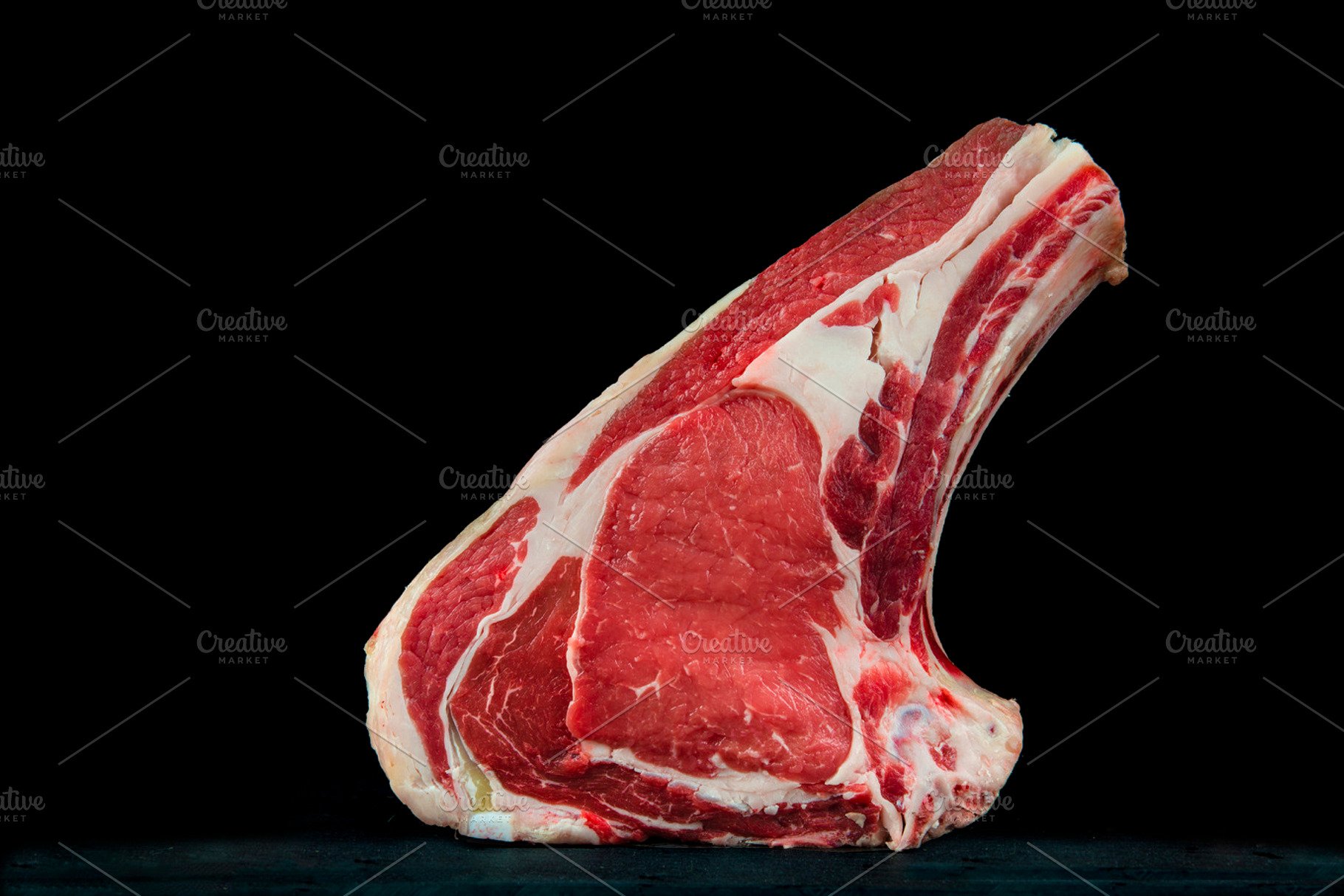 Raw veal steak on a black background stock photo containing t-bone steak and, a Food & Drink Photo by Angel Simon Photography