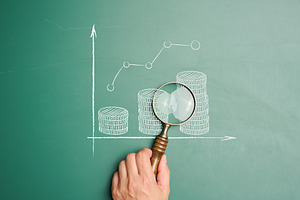 A hand holds a magnifying glass over a chalk growth chart and st, a Business Photo by ndanko