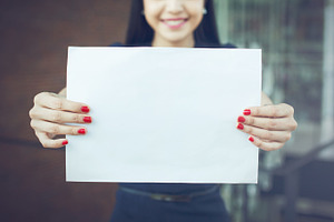 Half face of business woman holding an empty sign