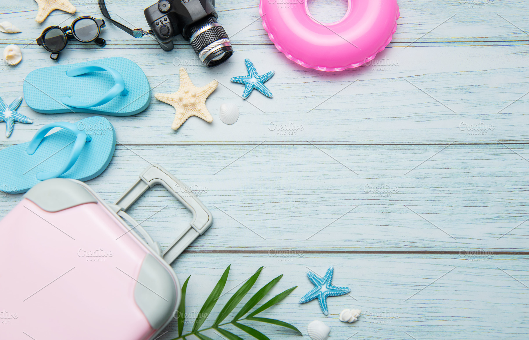 Pink suitcase, blue flip flops, pink lifebuoy and camera resting, a Holiday Photo by Olena Rudo