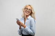 Excited businesswoman with smartphone smiling and looking at camera, female sec, a Photo by Prostock-Studio (Thumbnail 3 of 3)