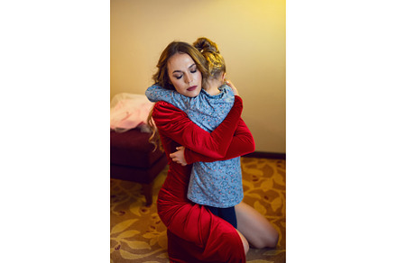 mother in red dress hugs her, a Person Photo by SaulichPhoto