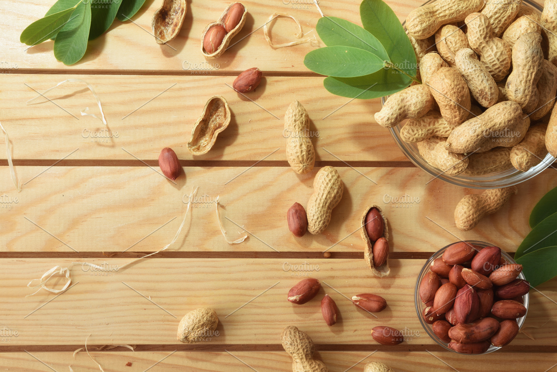 Bowls full of peanuts on wooden table decorated with leaves, a Food & Drink Photo by Davizro's Market