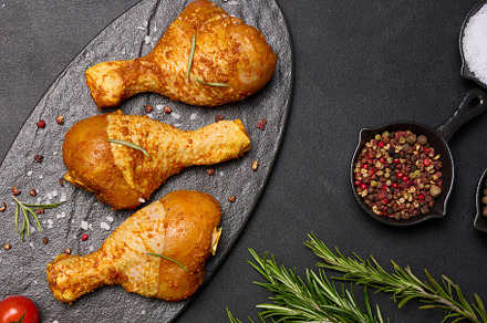 Raw chicken legs in spices on a black board, top view. Cooking w, a Food & Drink Photo by ndanko